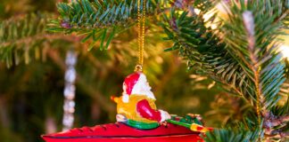 santa kayaking ornament on a christmas tree with gifts underneath