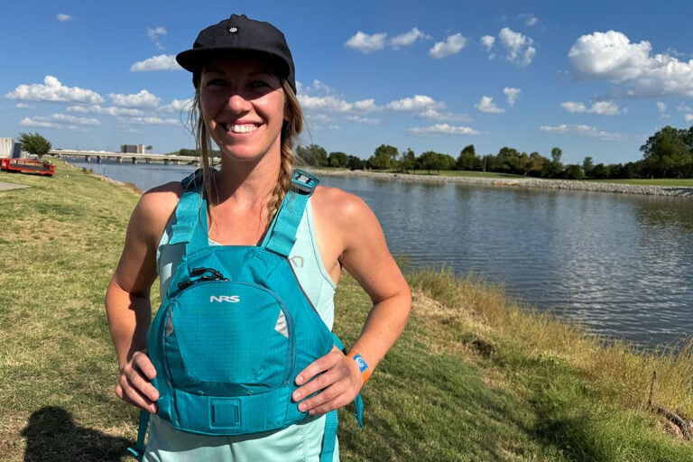 woman wearing an NRS Ninja PFD by riverside