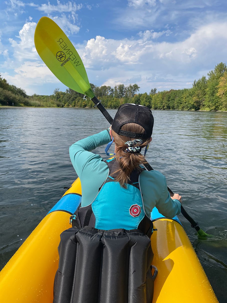 woman paddles in the bow seat of the Alpacka Tango