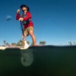 Man on paddleboard seen from water level.