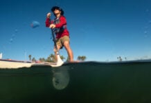 Man on paddleboard seen from water level.