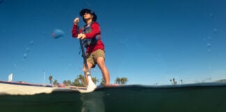 Man on paddleboard seen from water level.