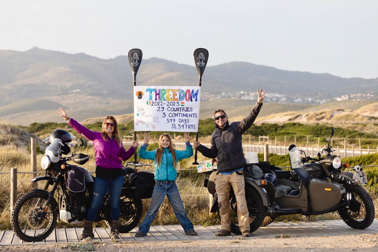 the Lawson family pose with sign and motorcycles while on their trip from Ireland to India