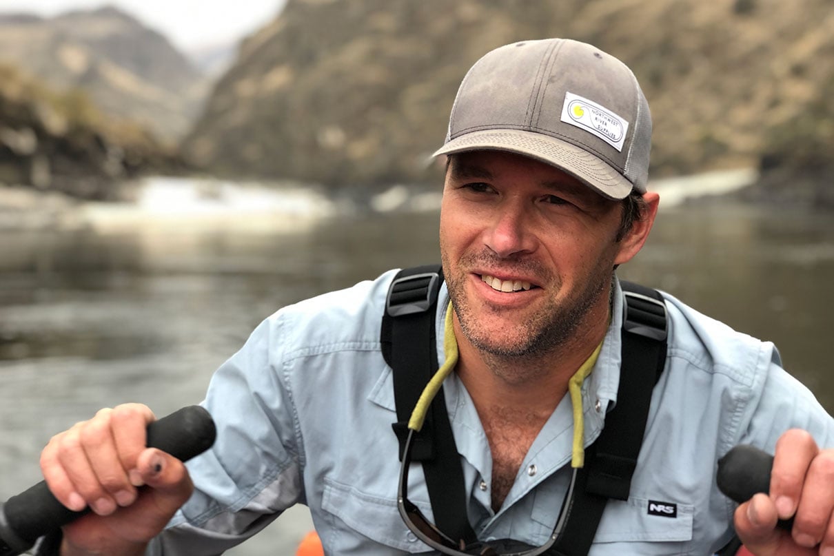 NRS employee Mark Deming rowing oars on a whitewater raft