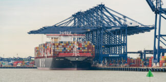 Kayaks paddling near cargo ship and port of trade.