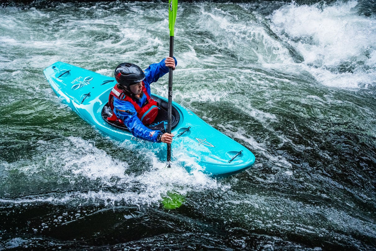 person paddles a Dagger whitewater kayak through rapids