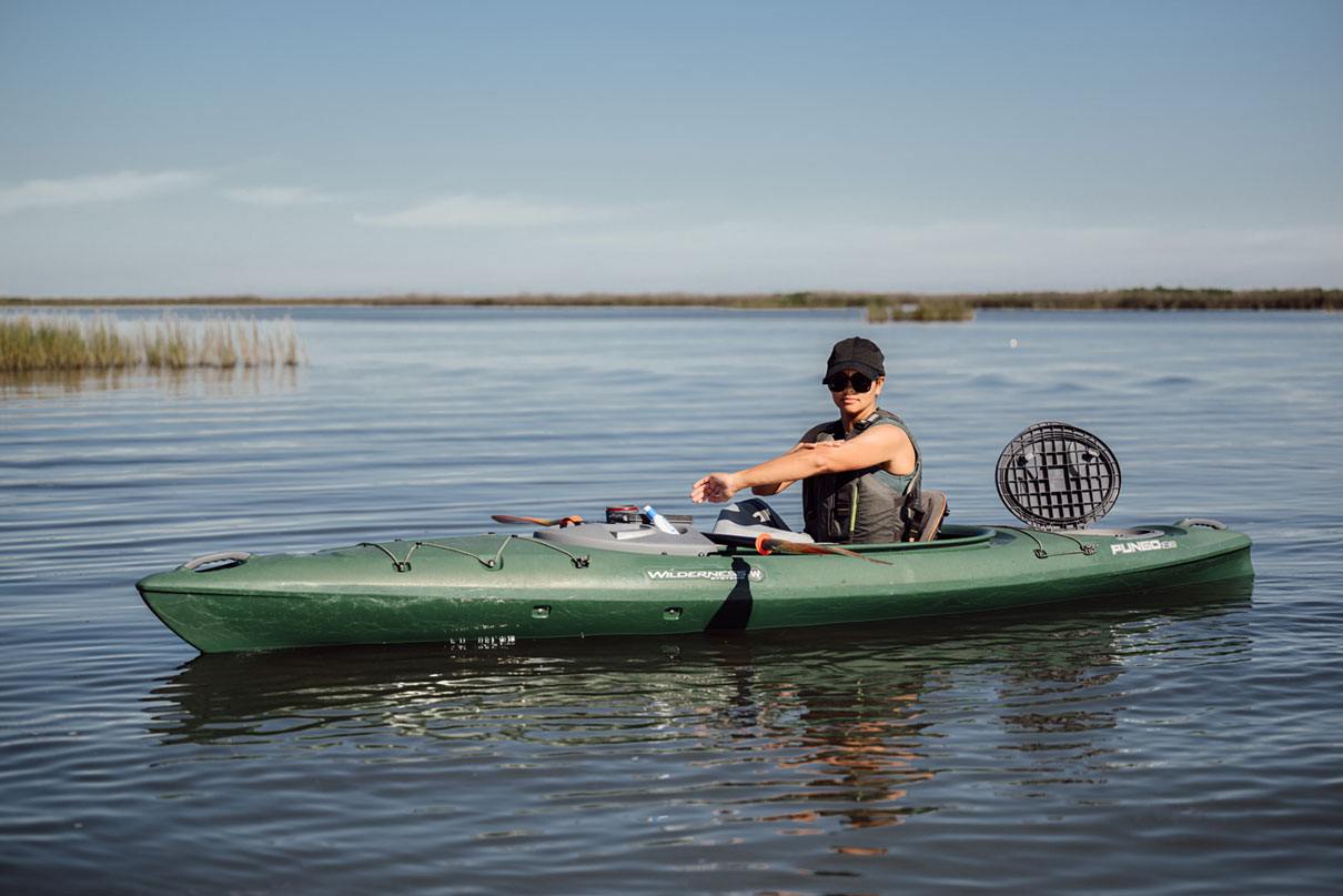 person paddles a sit-inside recreational kayak from Wilderness Systems