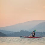 Best Kayaks For 2025 woman paddles the Eddyline Caribbean 10 kayak under rosy skies