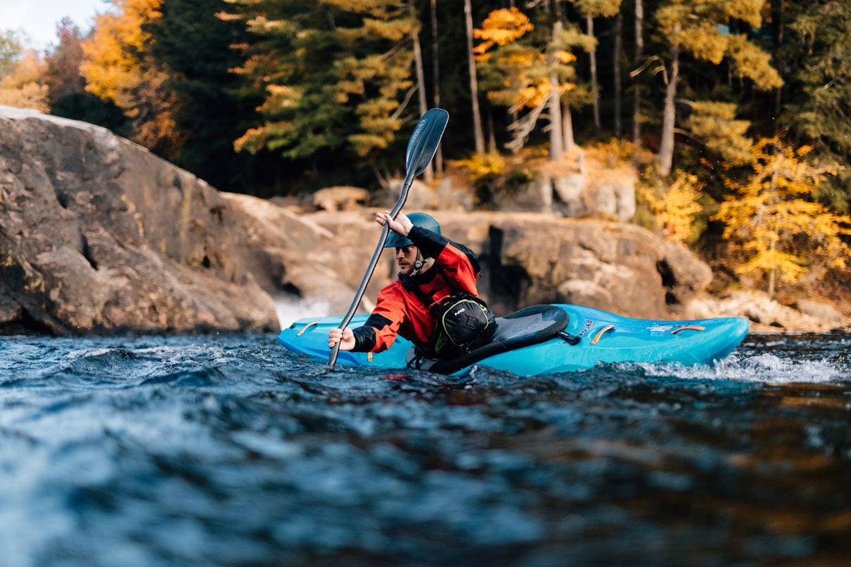 whitewater kayaker paddling through small riffles