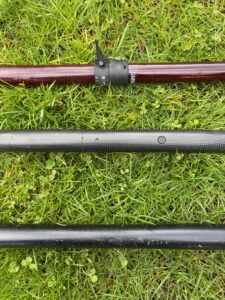 different types of multi-piece kayak paddle are laid out on grass