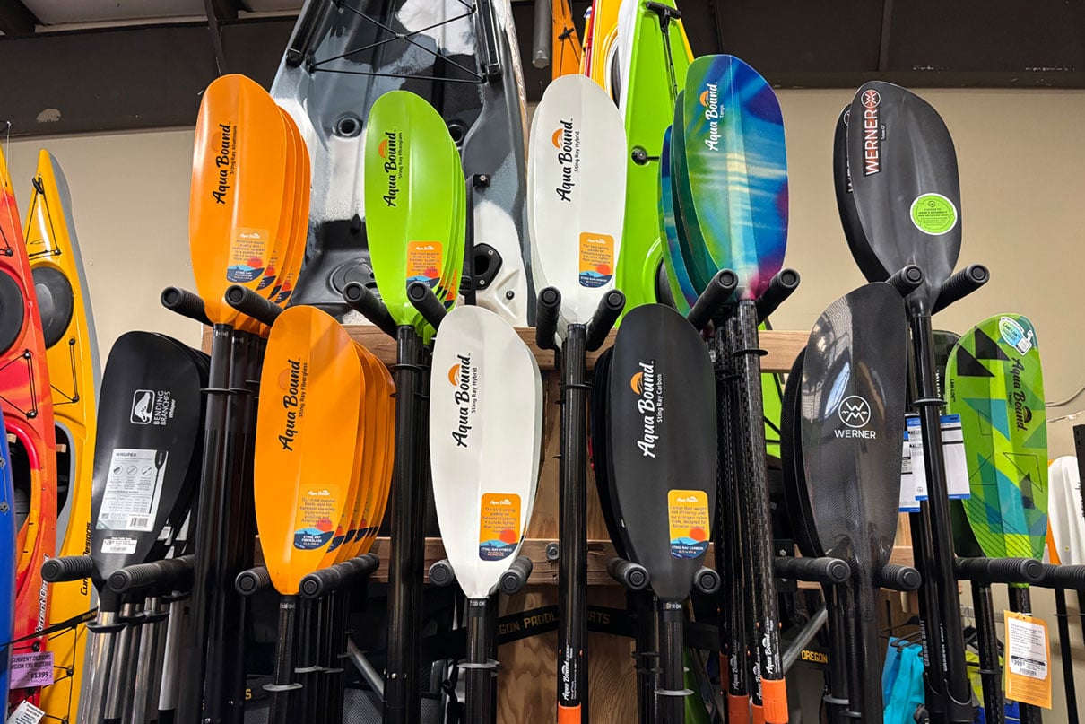 A collection of kayak paddle options on display at Oregon Paddle Sports