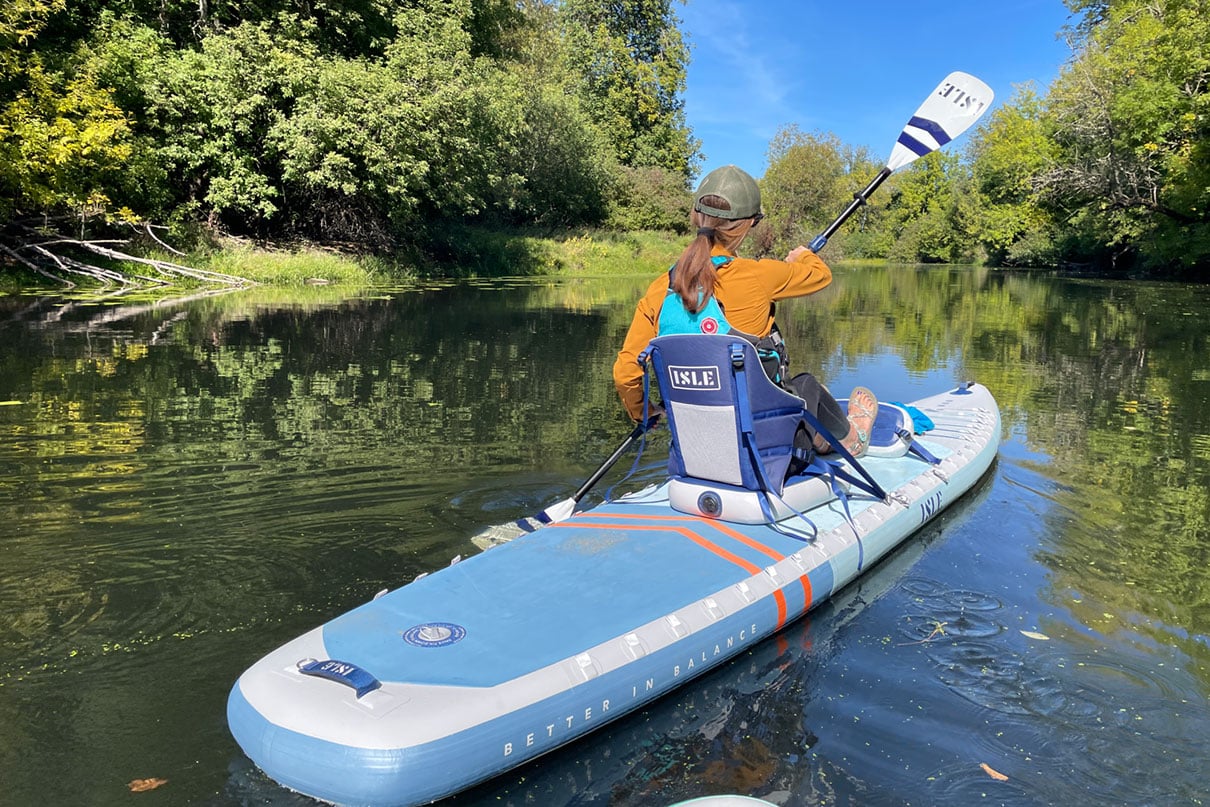 person paddles the ISLE Explorer Pro hybrid SUP-kayak