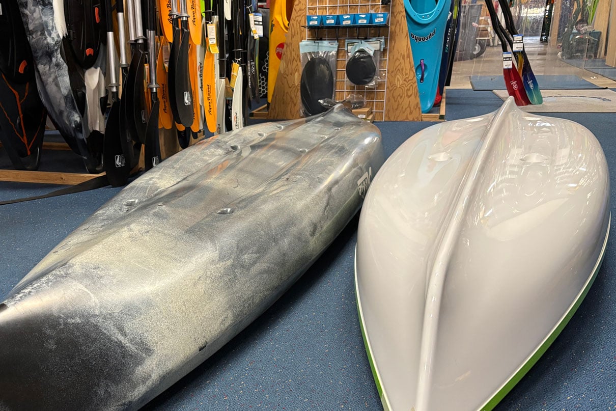 Eddyline Caribbean 10 and Hobie Quest 12.5 sit-on-top recreational kayaks sit overturned at Oregon Paddle Sports