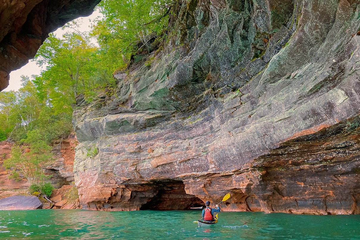 A sea kayaker in Cathedral Arch at the Meyers beach caves in the Apostle Islands National Lakeshore. Feature Image: Maddy Marquardt