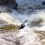 whitewater kayaker paddles through class IV rapid according the ISRD classification system