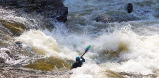 whitewater kayaker paddles through class IV rapid according the ISRD classification system