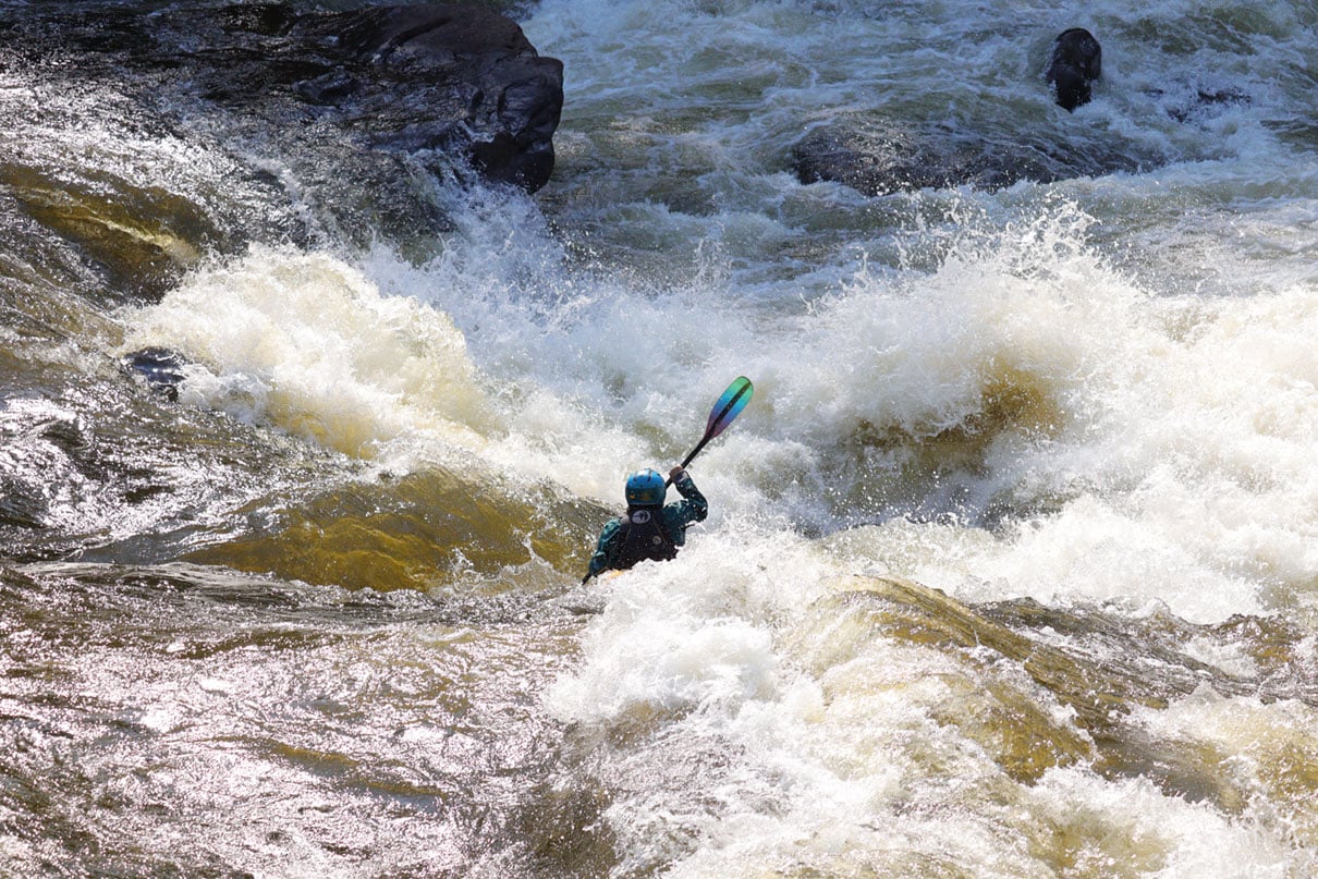 whitewater kayaker paddles through class IV rapid according the ISRD classification system