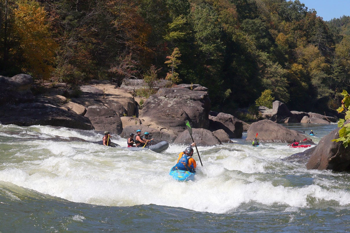 kayakers paddle down a Class V run on the Upper Gauley River