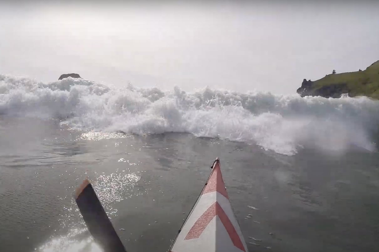 A huge wave barrels at Great Lakes Paddler Tim Gallaway