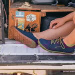 a perosn sits on a tailgate wearing Astral Loyak water shoes