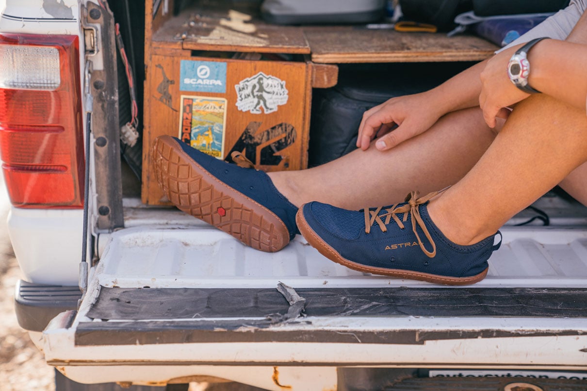 a perosn sits on a tailgate wearing Astral Loyak water shoes