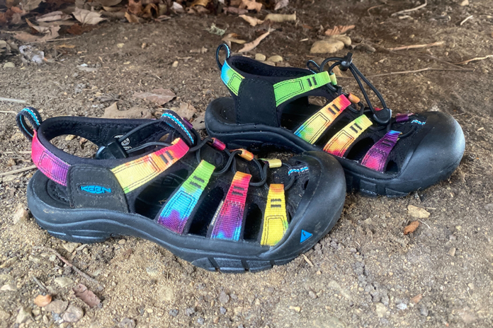 a pair of Keen Newport Retro water sandals sit on a dirt garage floor