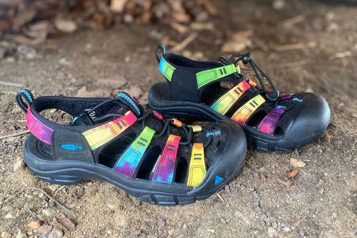 a pair of Keen Newport Retro water sandals sit on a dirt garage floor