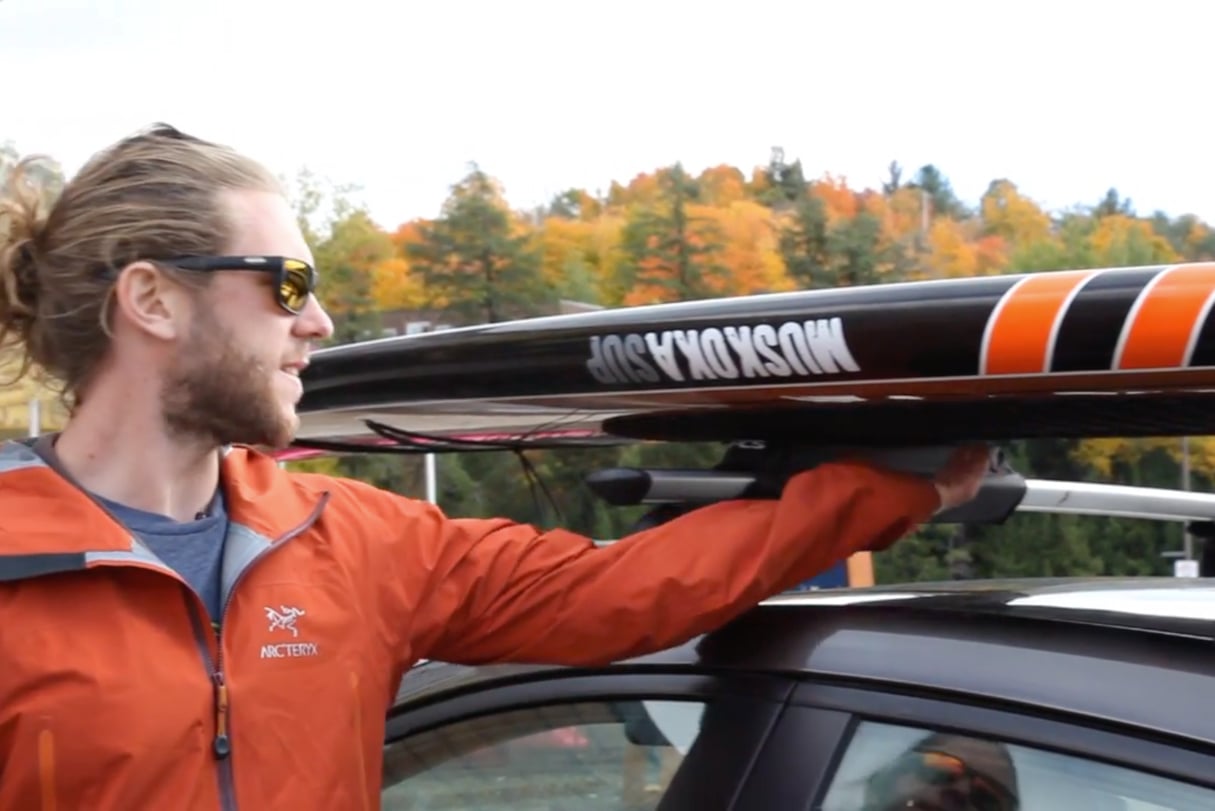 Paddleboard on roof rack facing down.