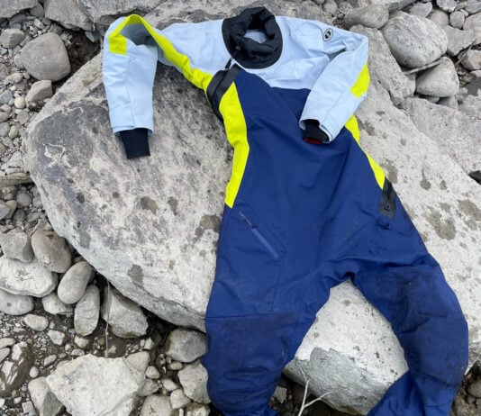 Image of the Helix Women's Drysuit by Mustang Survival on rocks by a river