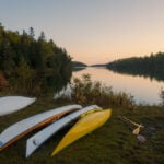 Image of sea kayaks on a shoreline in Michigan; some are registered and others are not
