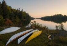 Image of sea kayaks on a shoreline in Michigan; some are registered and others are not