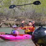 A kid in the front of a tandem kayak at the 3 Rivers Rendezvous
