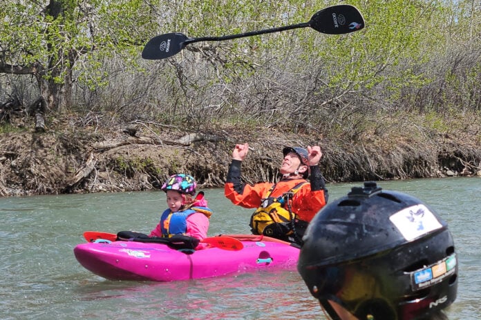 A kid in the front of a tandem kayak at the 3 Rivers Rendezvous