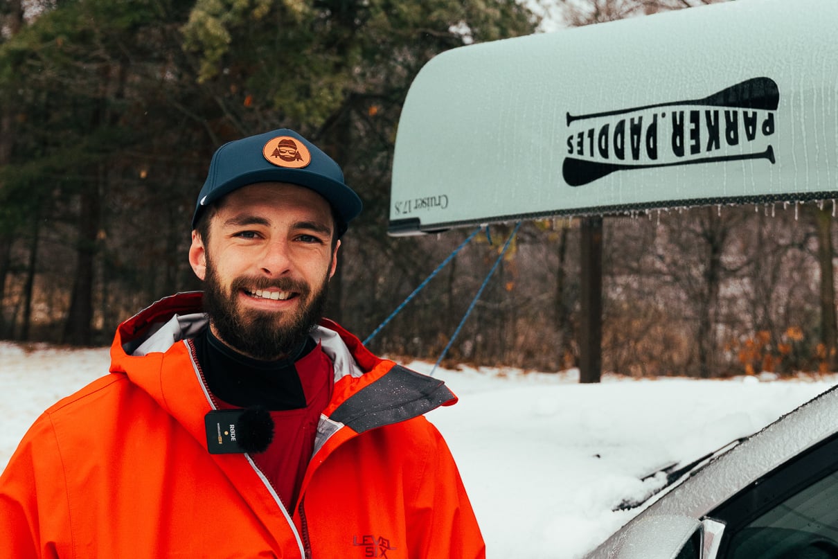 Kyle Parker in front of a canoe