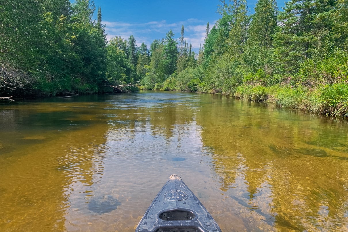 A canoe floats down the sandy-bottomed Jordan River in Michigan